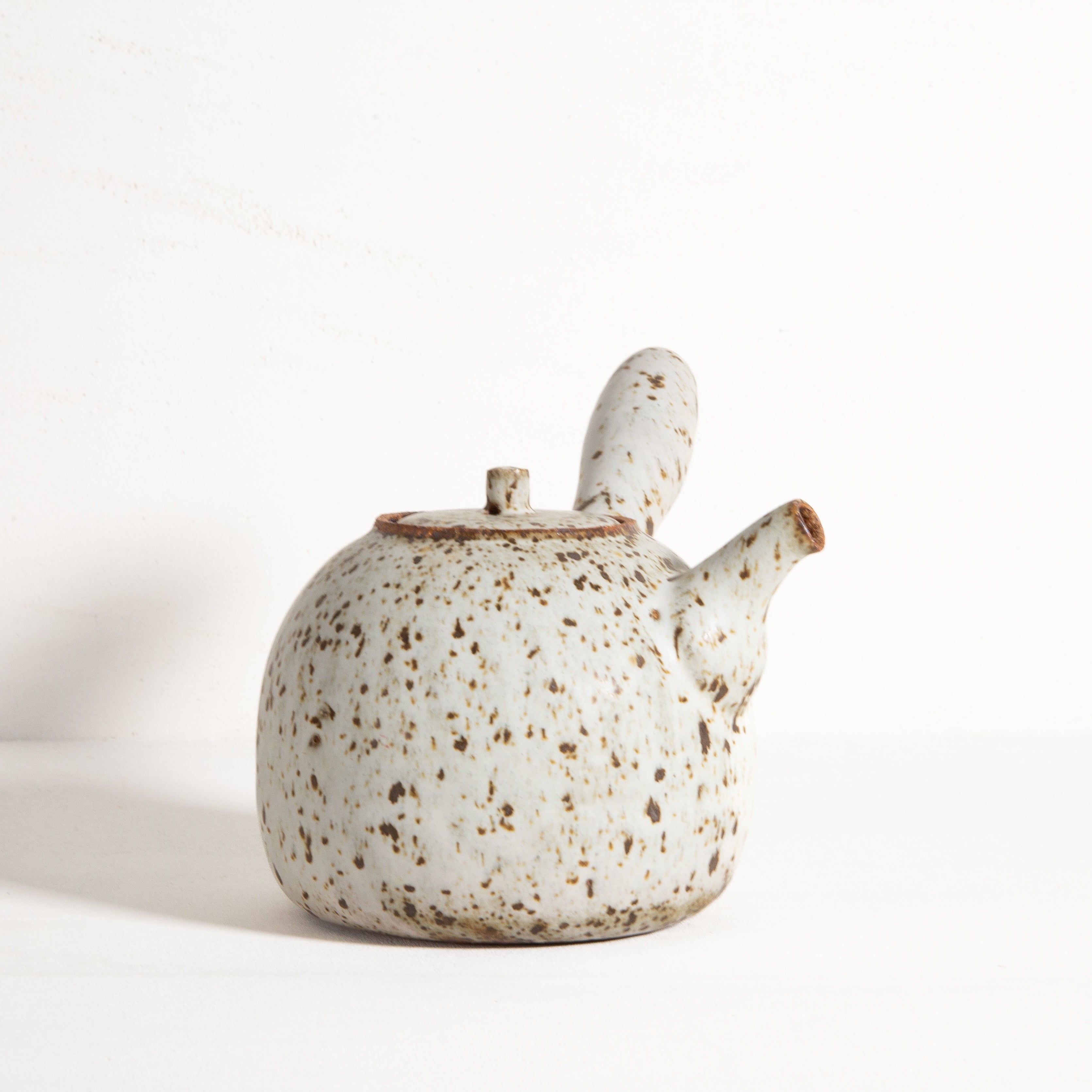 Speckled ceramic teapot on a white background